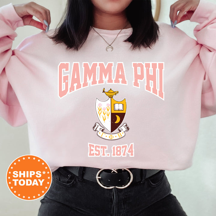 a woman wearing a pink sweatshirt with the words gama phi on it