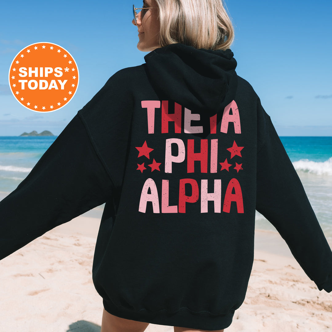 a woman wearing a black hoodie that says theia phih alpha