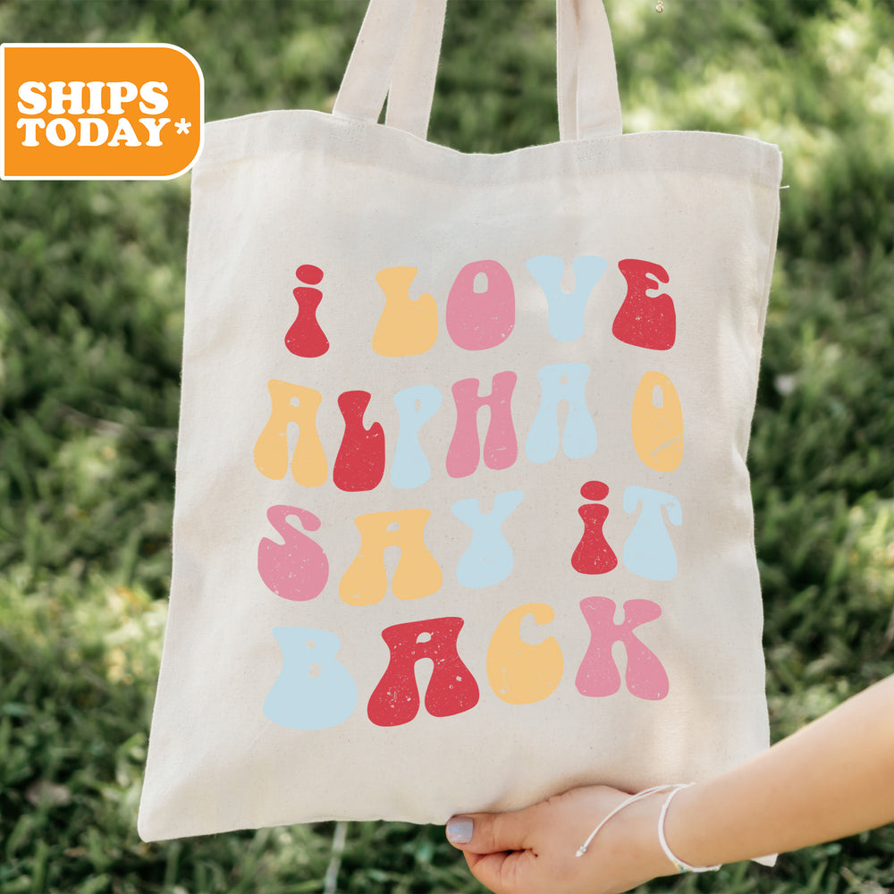 a person holding a tote bag with the words love all over it