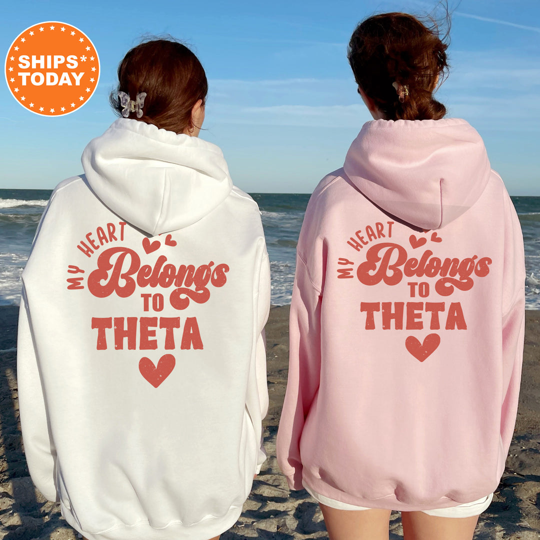 two women wearing matching sweatshirts on the beach