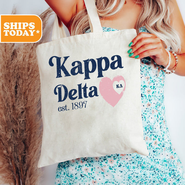 a woman holding a tote bag that says kappa delta
