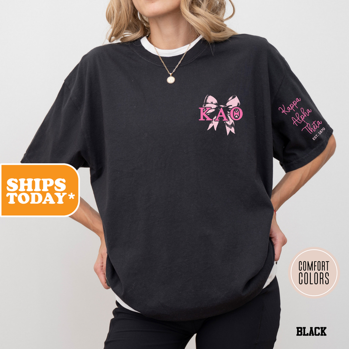 a woman wearing a black shirt with a pink bow on it