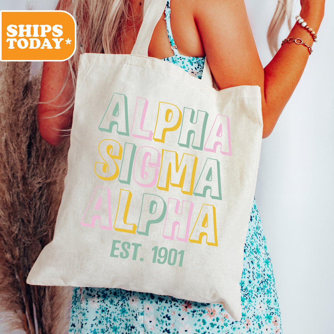a woman holding a white bag with the words alpha sigma alpa