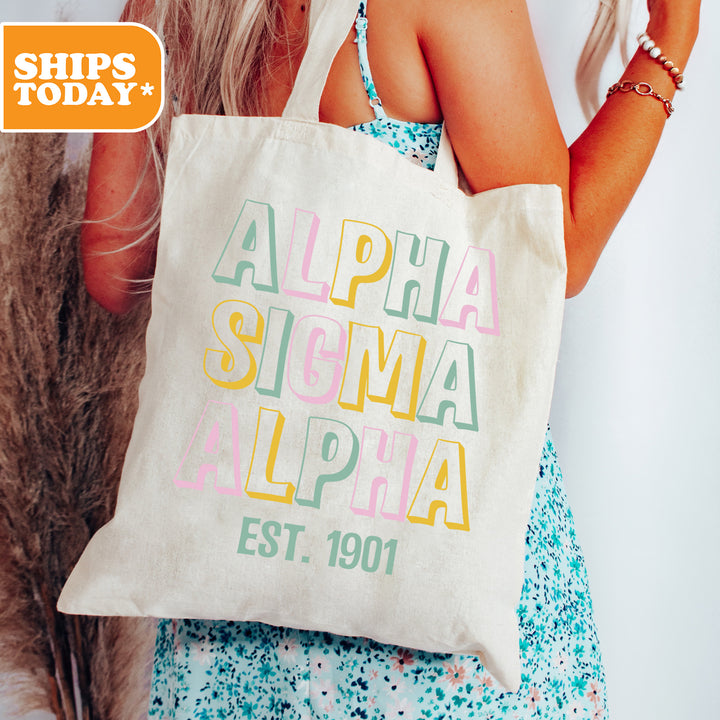 a woman holding a white bag with the words alpha sigma alpa
