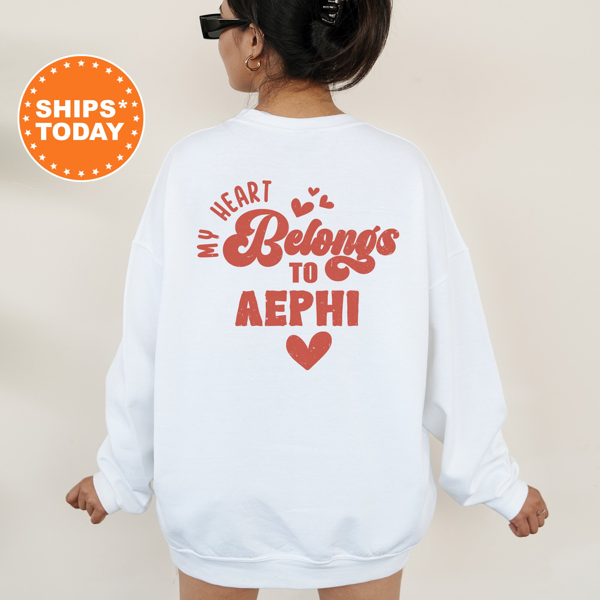 a woman wearing a white sweatshirt with the words heart belongs to aeph