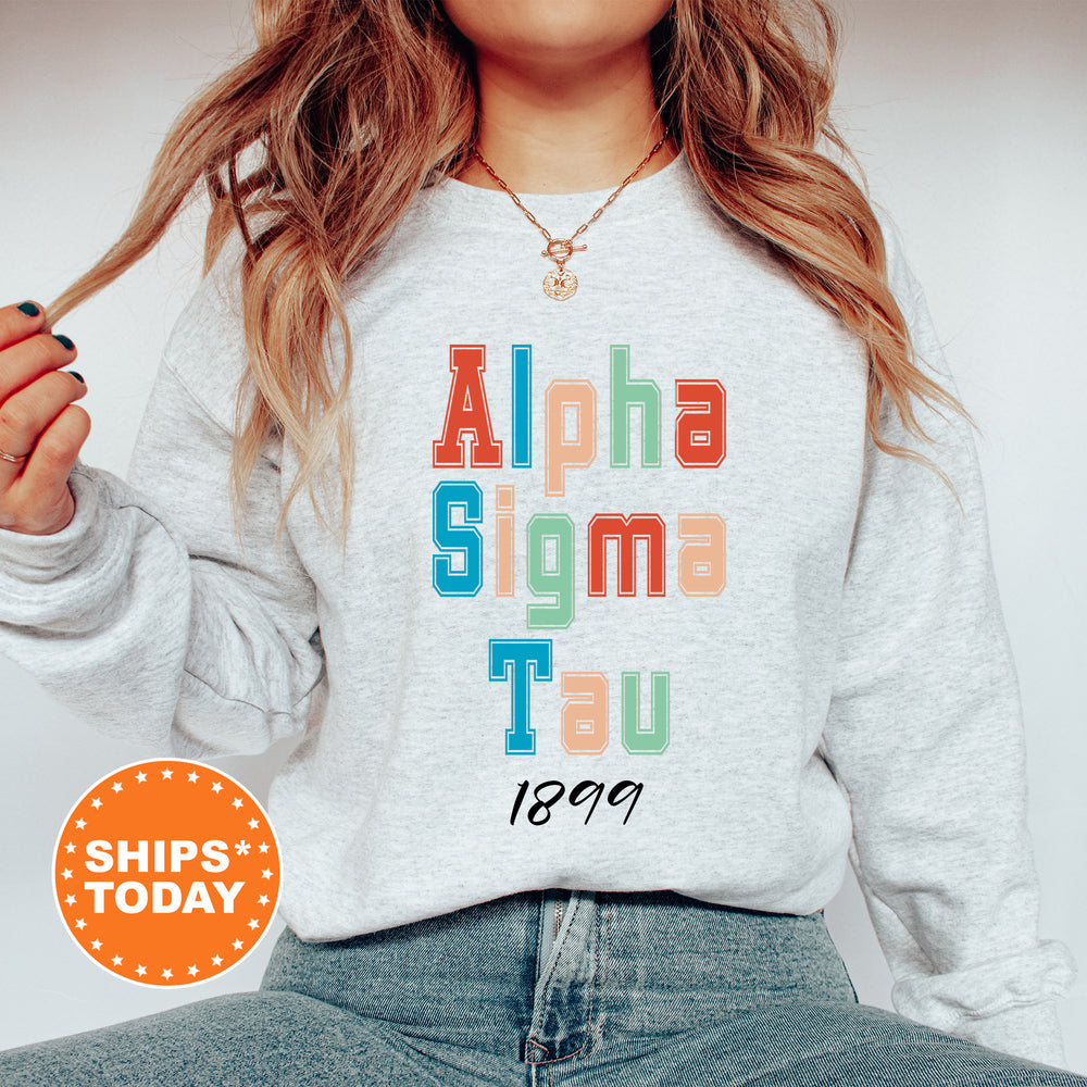 a woman wearing a sweatshirt that says alpha sigmma tau