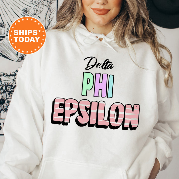 a woman wearing a white sweatshirt with the words delta phi epsilon on it