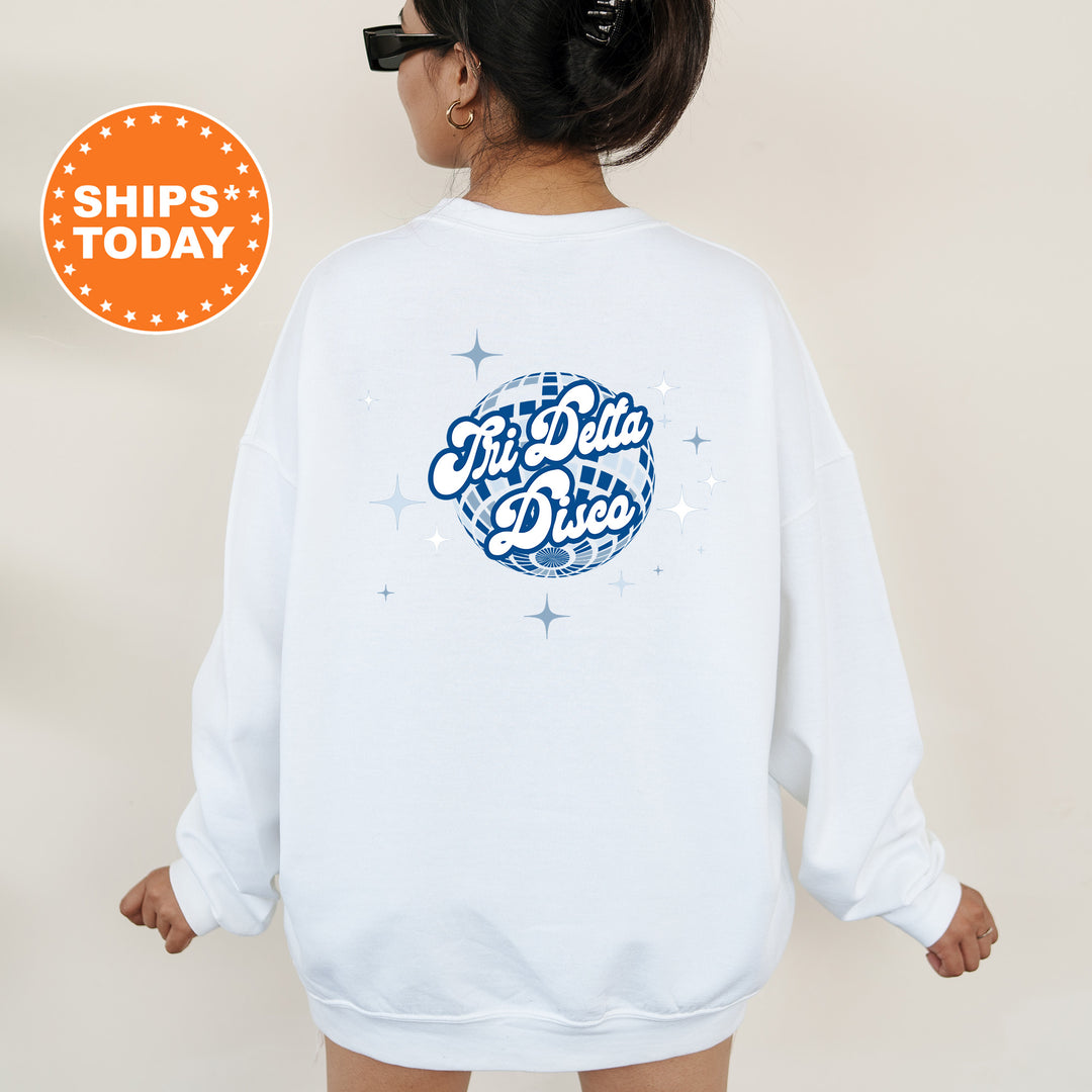 A person wearing a white sweatshirt with a graphic design on the back, featuring a blue and white disco ball and stars.