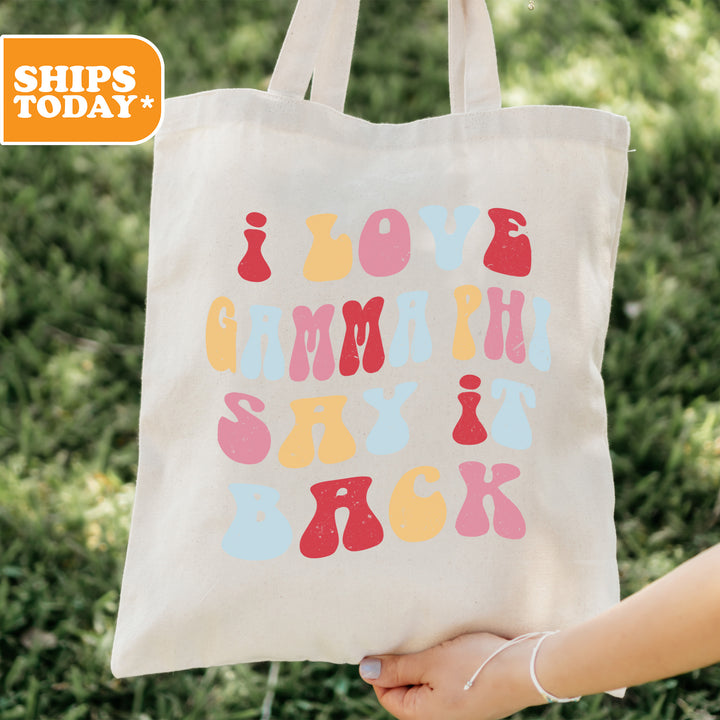 a person holding a tote bag with the words love, laugh, and back