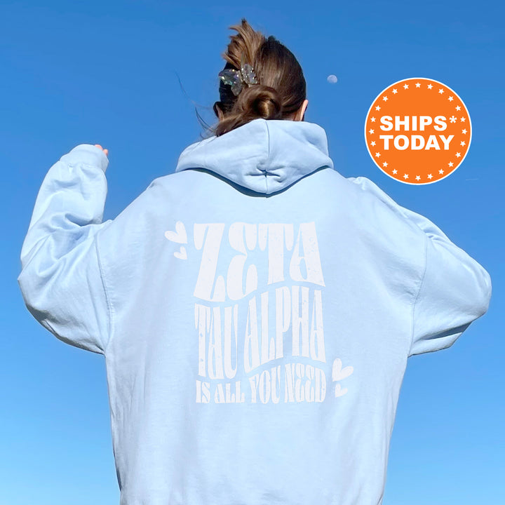 a woman wearing a white hoodie with a blue sky in the background