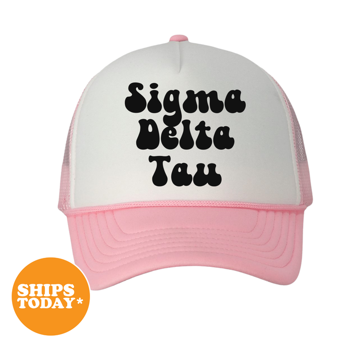 A white and pink baseball cap with the text " Sigma Delta Tau" printed on it.