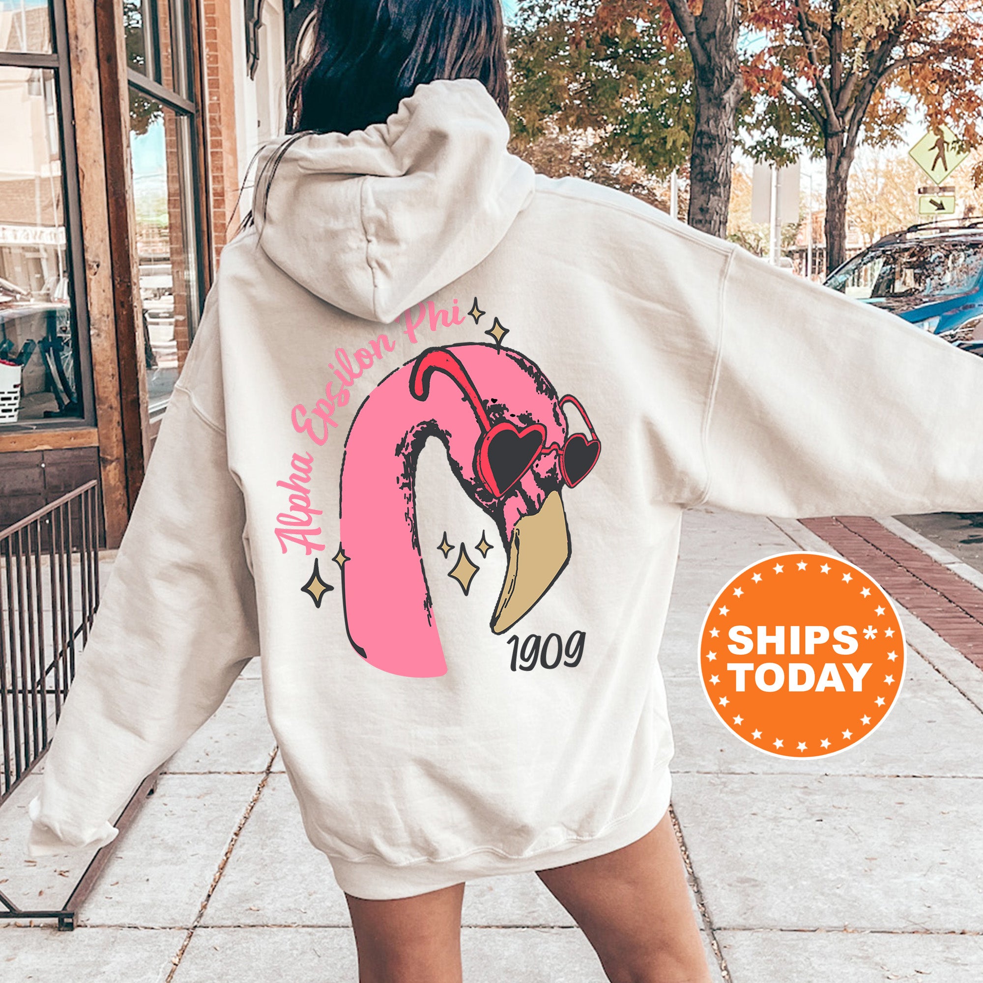 a woman walking down a sidewalk wearing a white hoodie