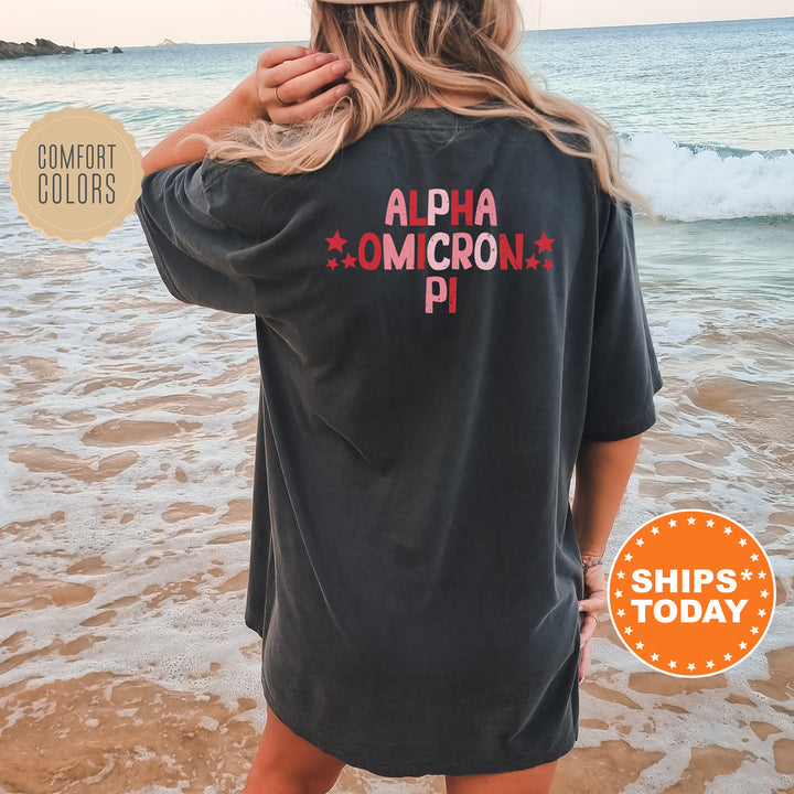 a woman standing on a beach wearing a black shirt