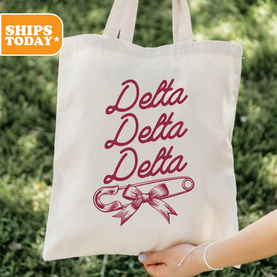 a person holding a tote bag that says delta delta delta