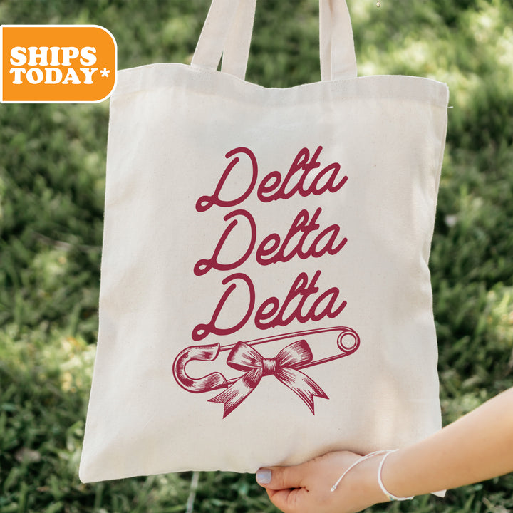 a person holding a tote bag that says delta delta delta
