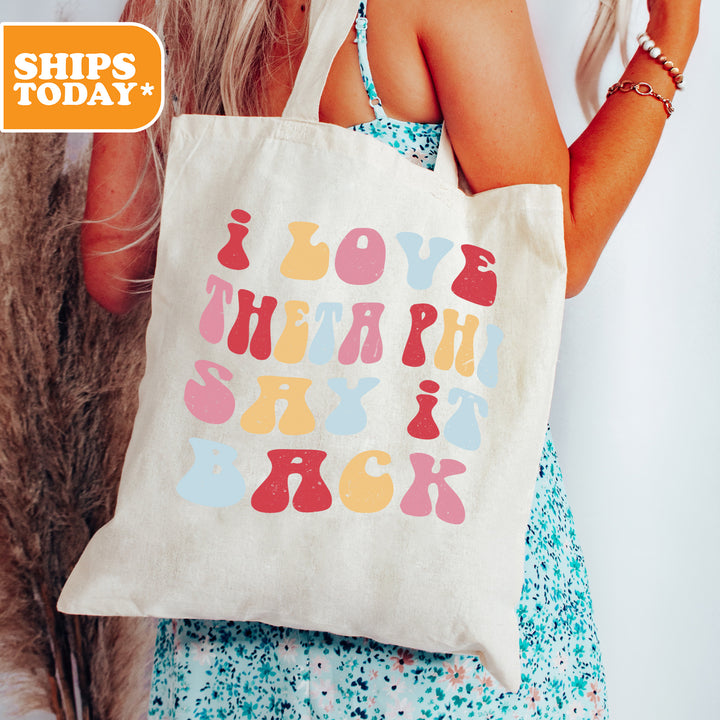 a woman holding a tote bag with a message on it