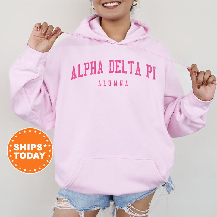 a woman wearing a pink hoodie with the words aloha delta pi on