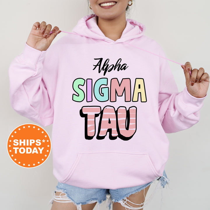 a woman wearing a pink hoodie that says, ahha sigma tau