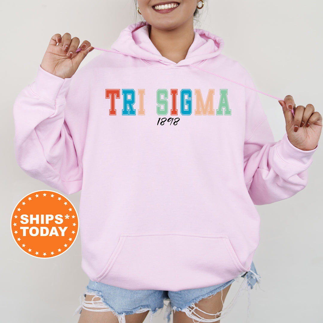 a woman wearing a pink hoodie with the word tri stigma on it