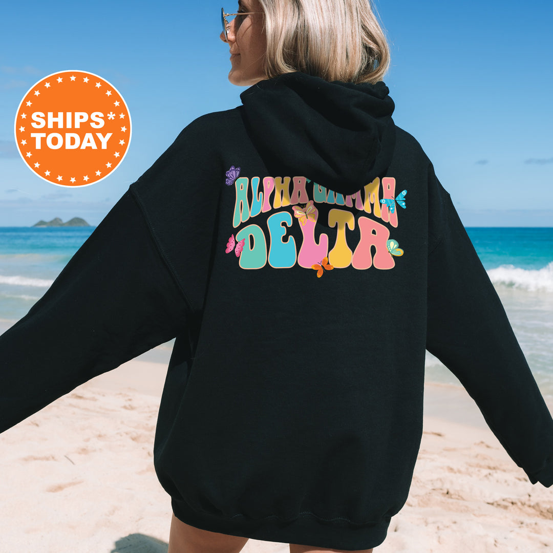 a woman in a black hoodie is walking on the beach
