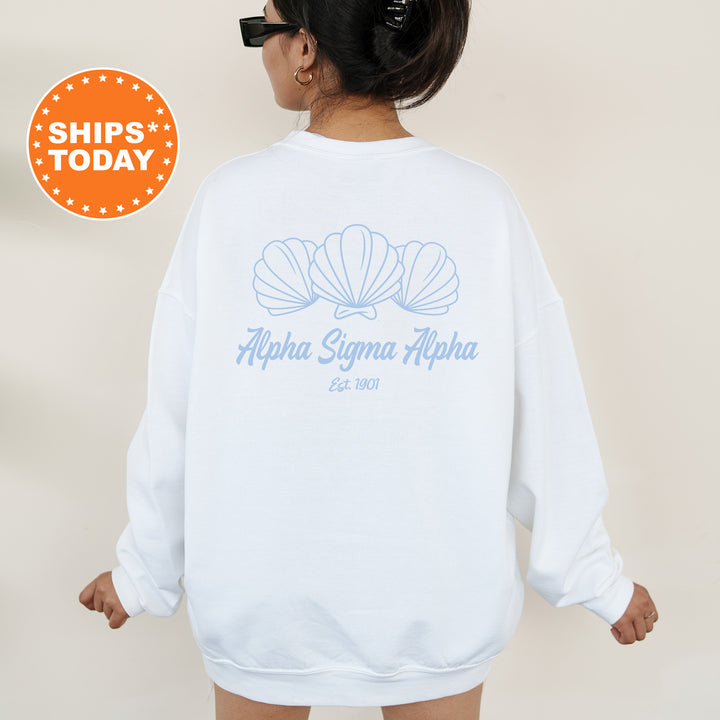 A woman wearing a white sweatshirt with the logo of Alpha Sigma Alpha sorority printed on it.