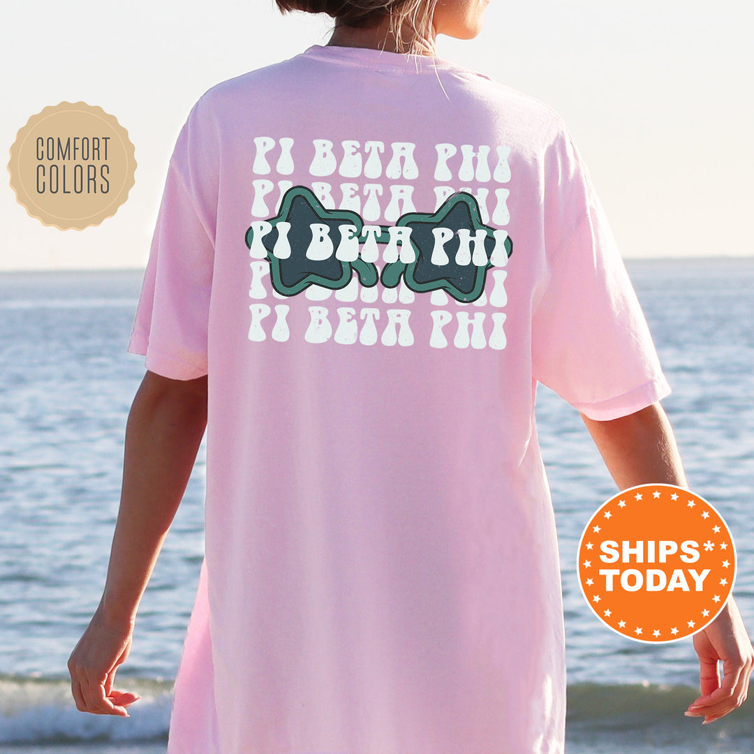a woman standing on a beach wearing a pink shirt