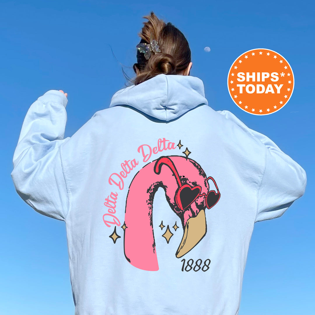 a woman wearing a white sweatshirt with a pink flamingo on it