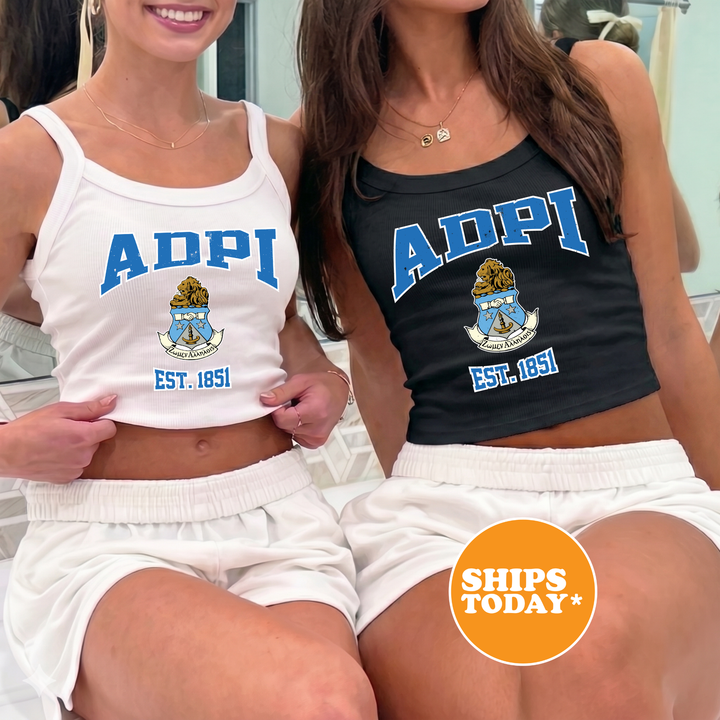 Two women wearing tank tops with the text "ADPI" and "EST. 1851" are sitting next to each other.