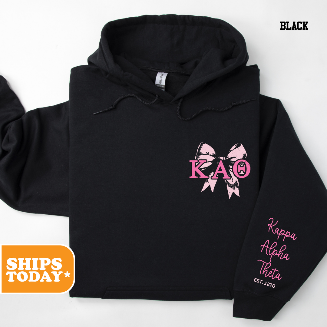 a black hoodie with a pink bow on it