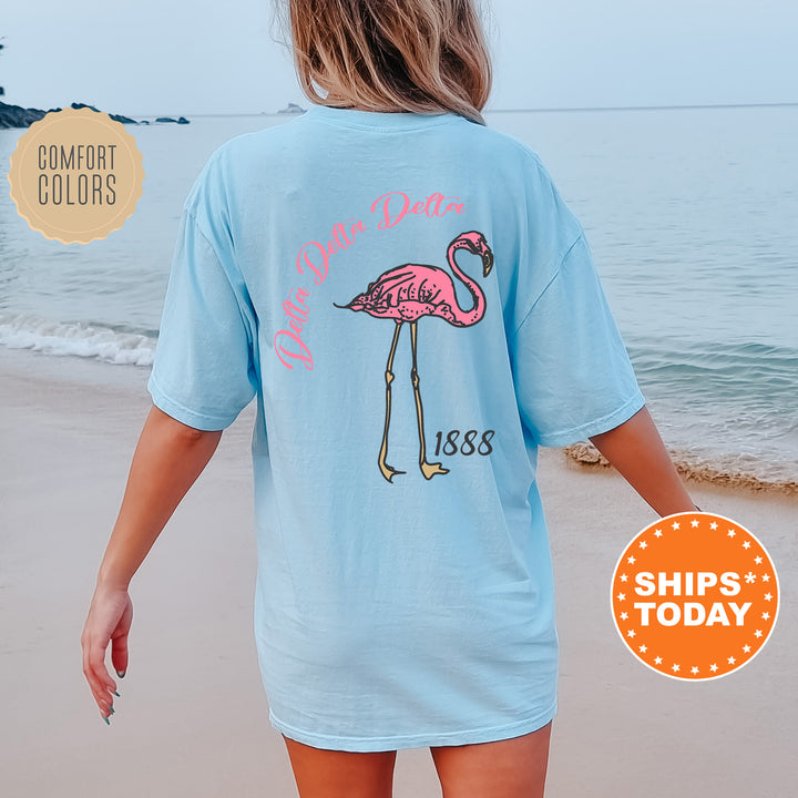 a woman walking on the beach with a pink flamingo t - shirt