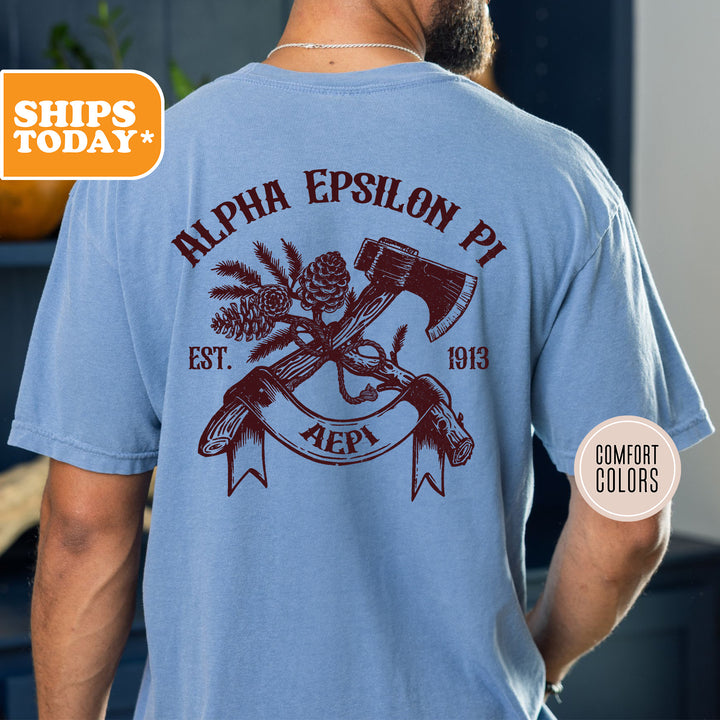 a man wearing a blue shirt with an image of an axe and pine cones on
