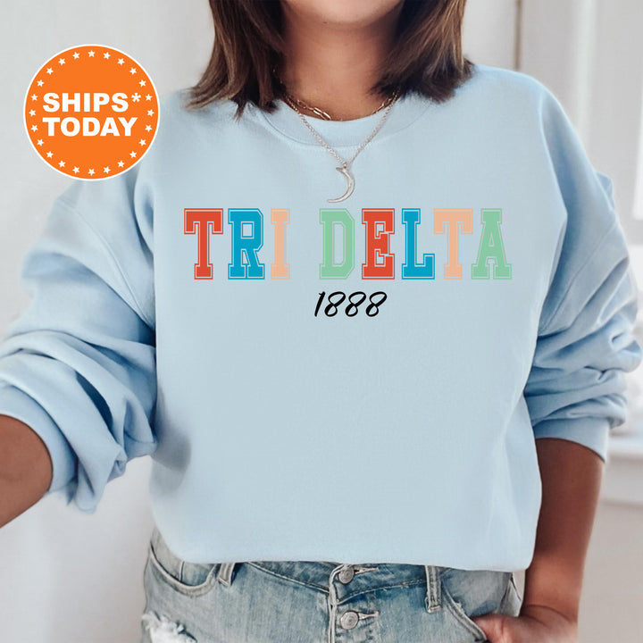 a woman wearing a light blue sweatshirt with the words tridelta printed on it