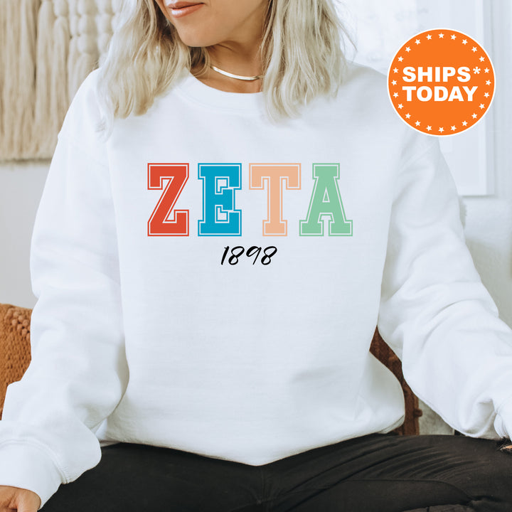 a woman wearing a white sweatshirt with the word zeta printed on it