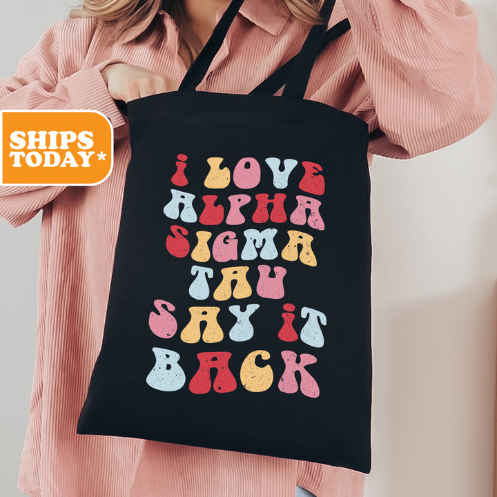 a woman holding a black shopping bag with colorful letters