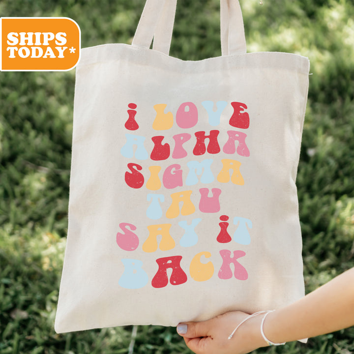 a person holding a tote bag with letters on it