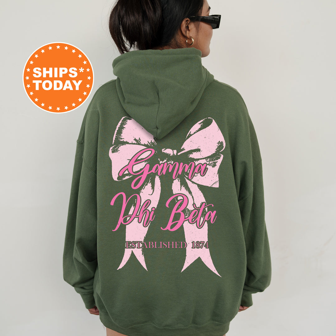 a woman wearing a green hoodie with a pink bow on it