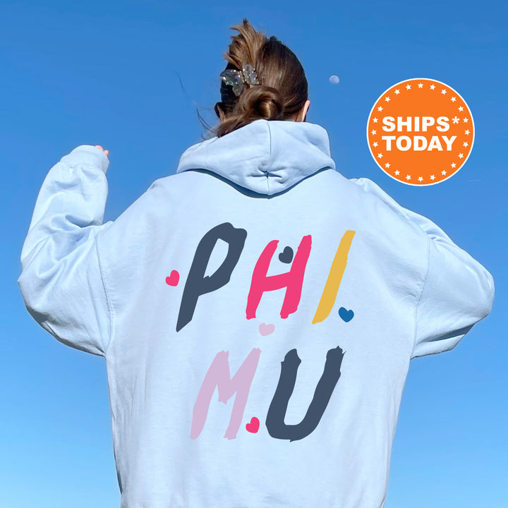a woman wearing a white hoodie with the words phi mu on it