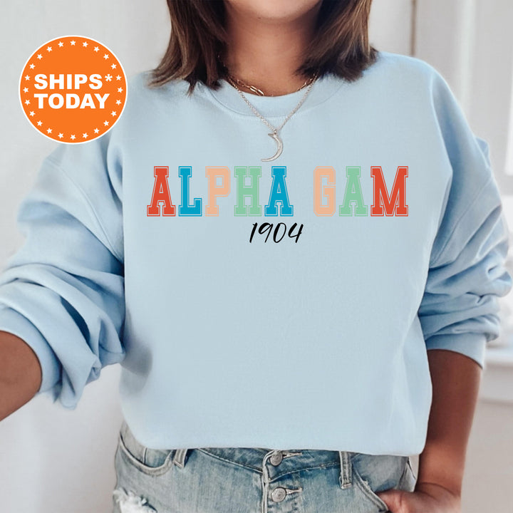 a woman wearing a light blue sweatshirt with the words alpaga cam on it