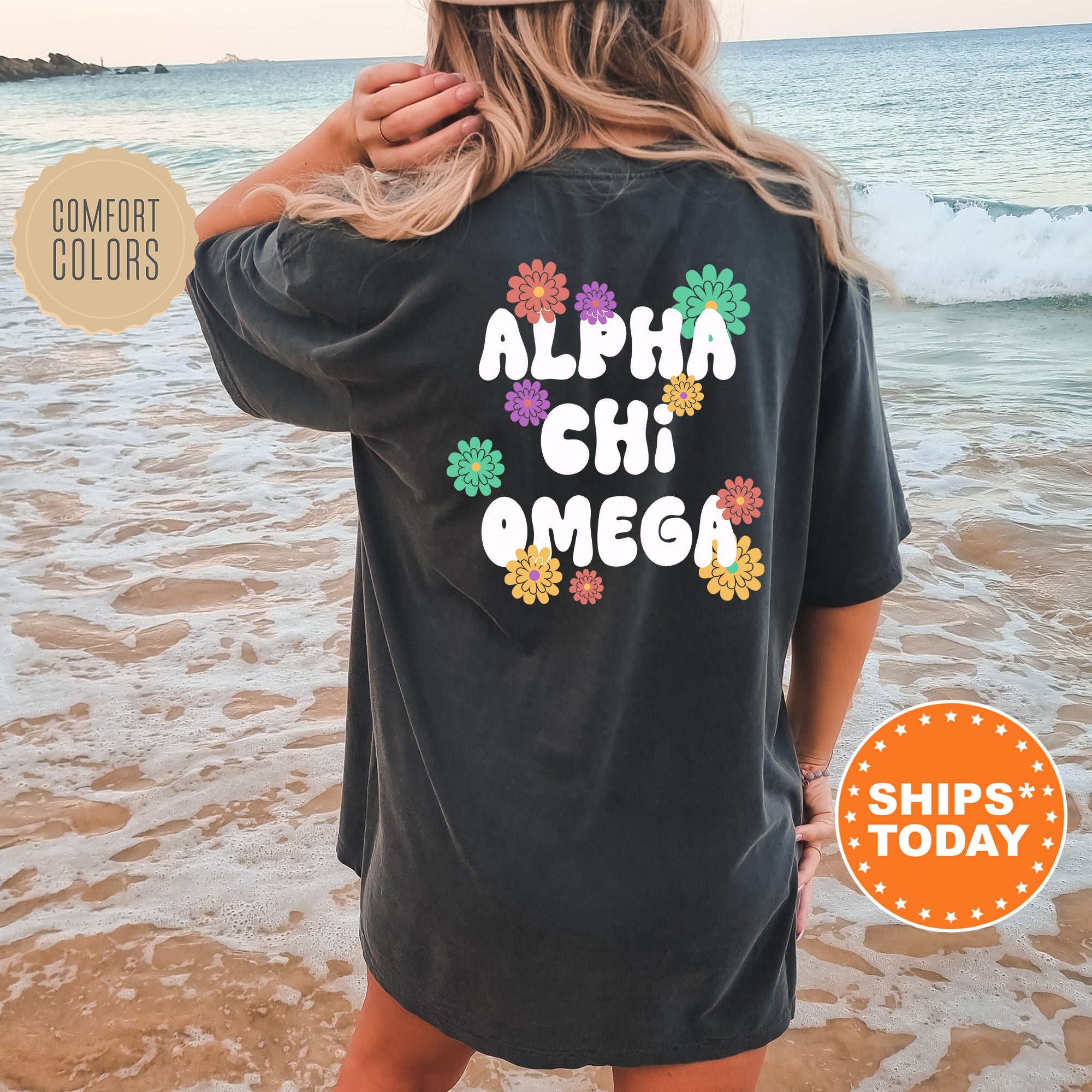 a woman standing on a beach wearing a black shirt