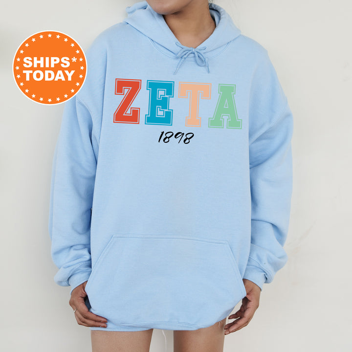 a woman wearing a blue hoodie with the word zeta on it