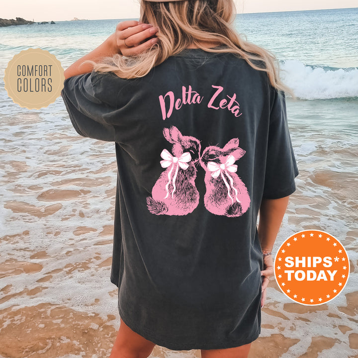 a woman standing on a beach wearing a black shirt
