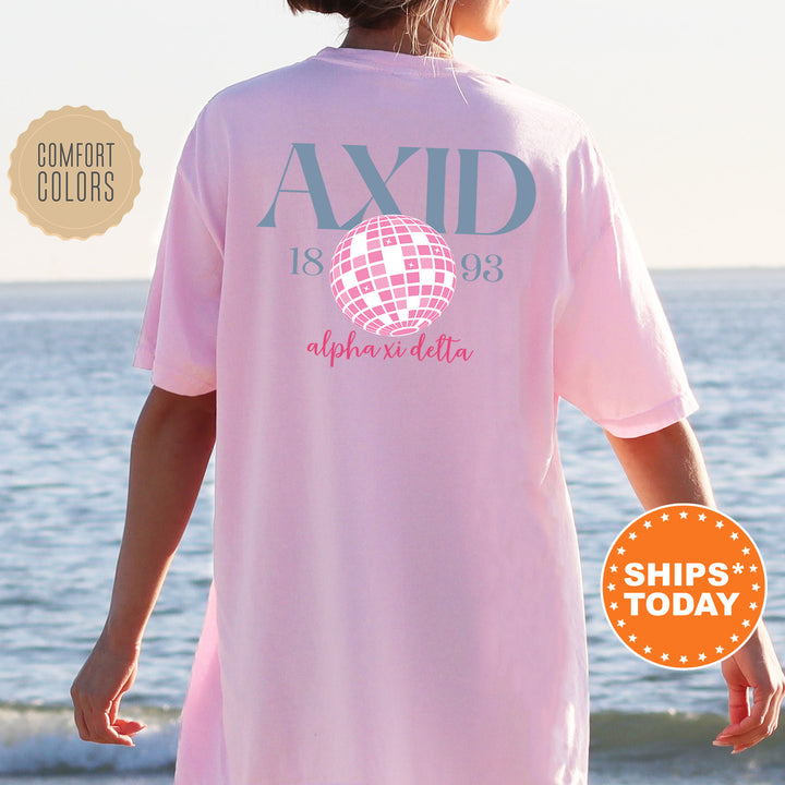 a woman wearing a pink shirt with a disco ball on it
