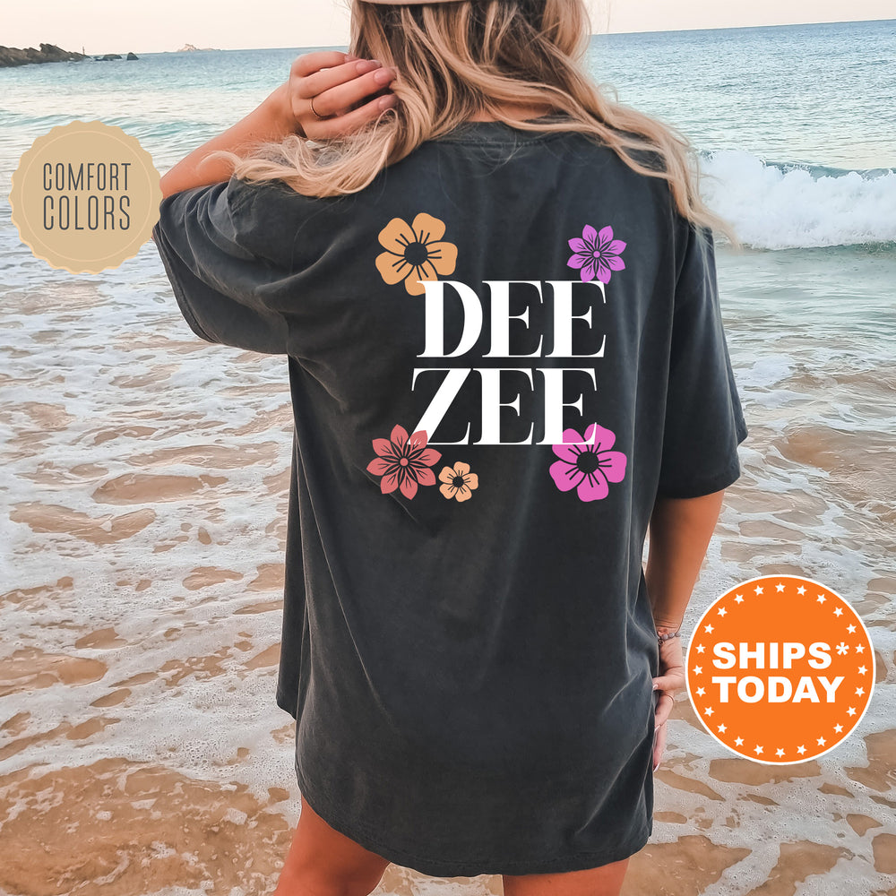 a woman standing on a beach wearing a t - shirt that says dee zee