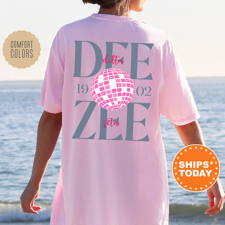 a woman wearing a pink shirt with a disco ball on it