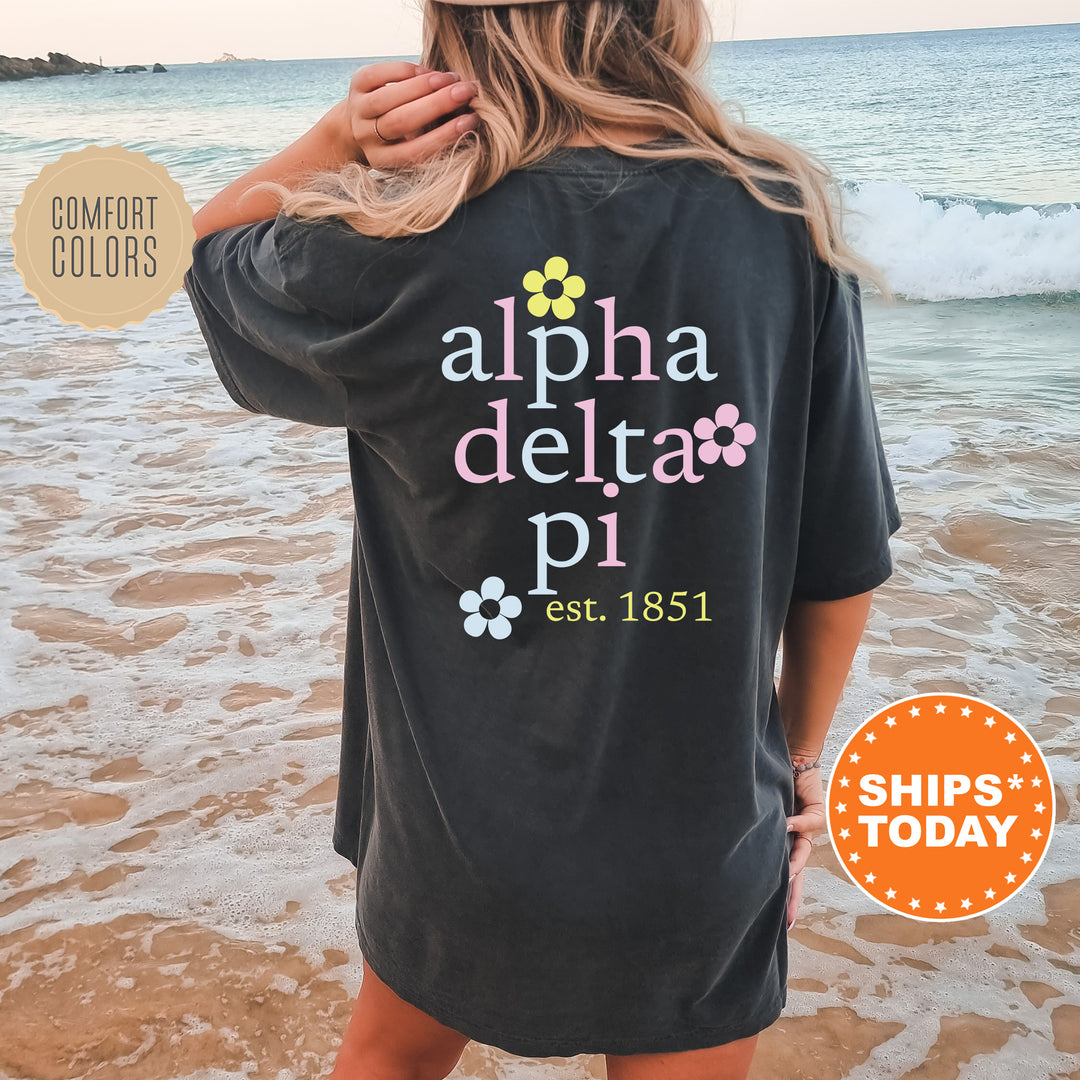 a woman standing on a beach wearing a black shirt