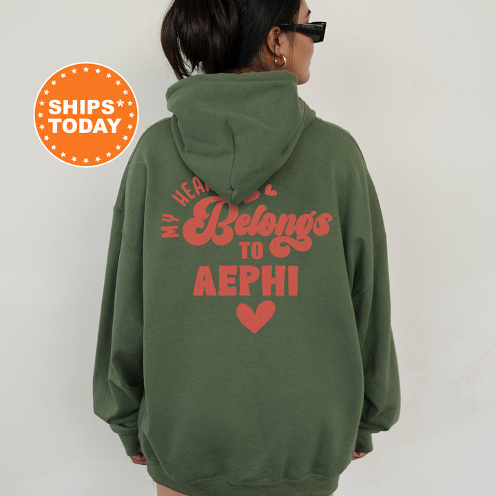 a woman wearing a green hoodie with a red heart on it