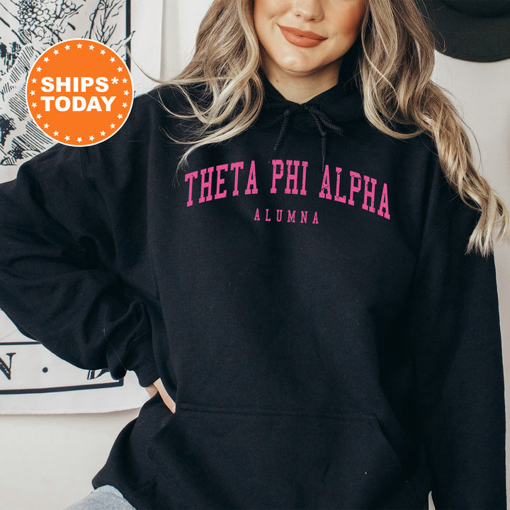 a woman wearing a black hoodie with pink letters
