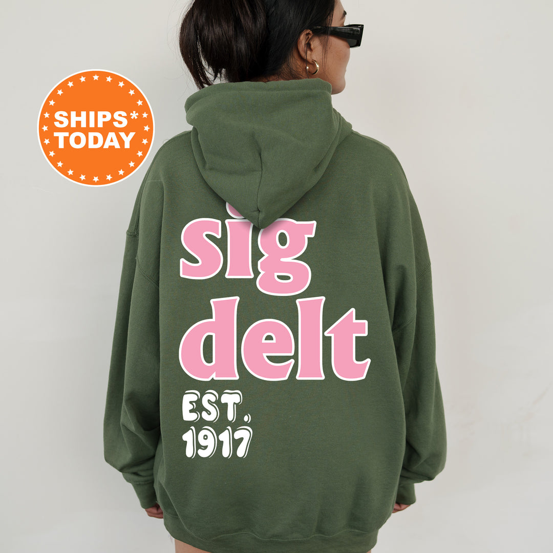 A person wearing a green hoodie with pink text and numbers on the back.