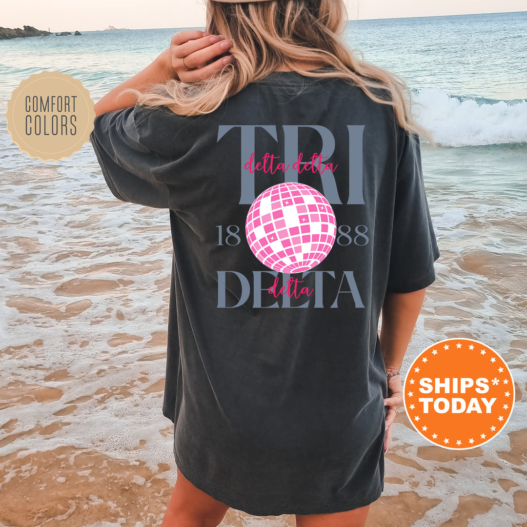 a woman standing on a beach wearing a t - shirt