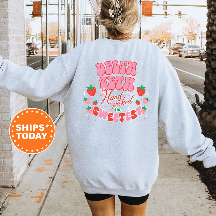 a woman walking down a sidewalk wearing a sweatshirt